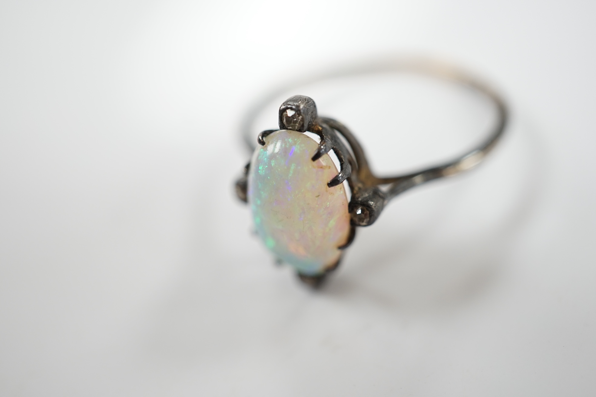 An antique, yellow and white metal, white opal and diamond set ring, size T, gross weight 2.1 grams. Condition - poor to fair